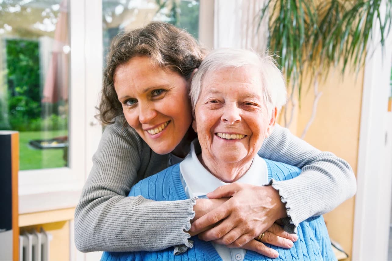 A caregiver sharing a warm hug with an older adult